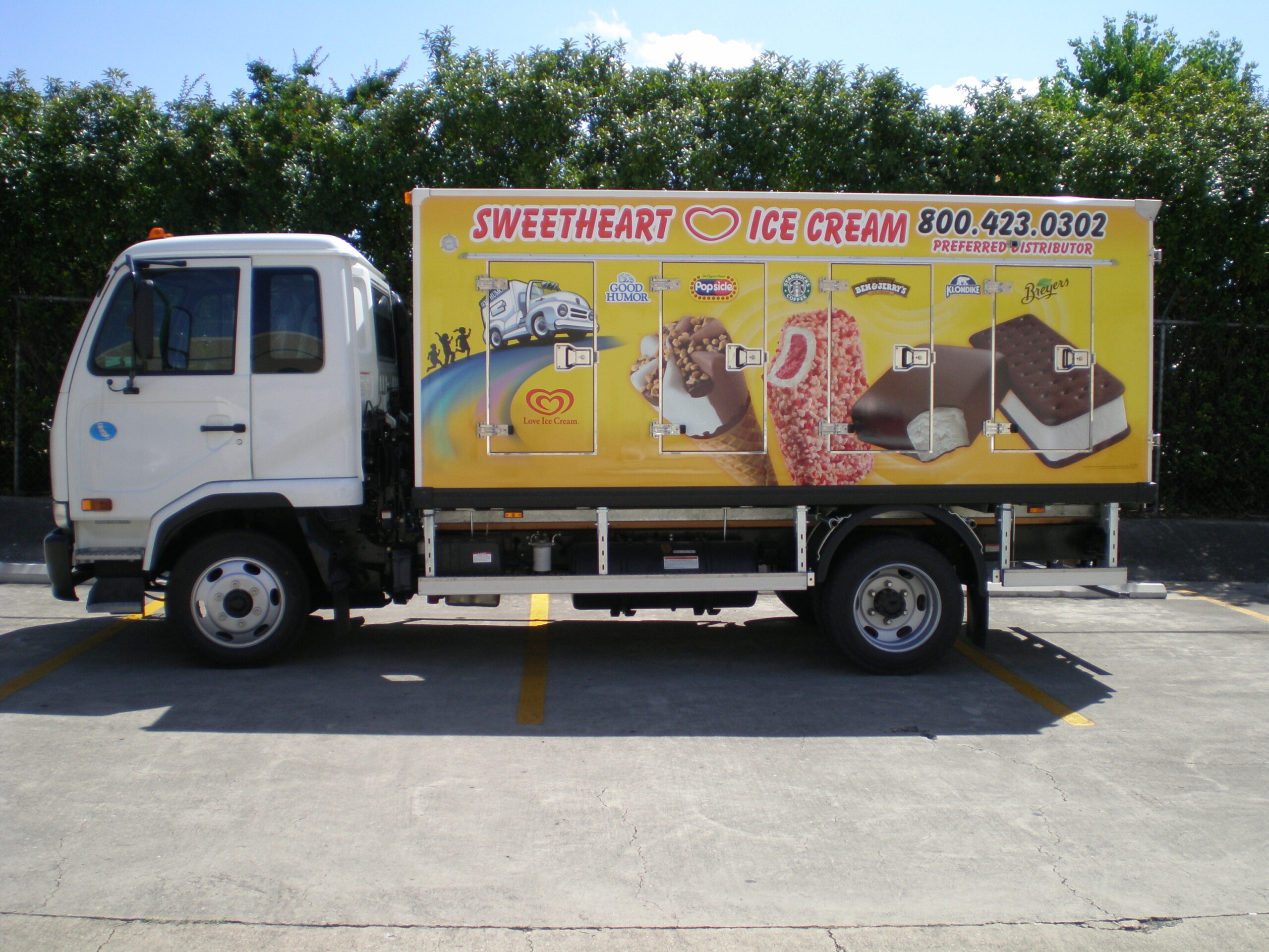 Ice cream truck with a colorful Sweetheart Ice Cream advertisement featuring various ice cream products, parked in a lot, emphasizing vehicle branding and promotional design.