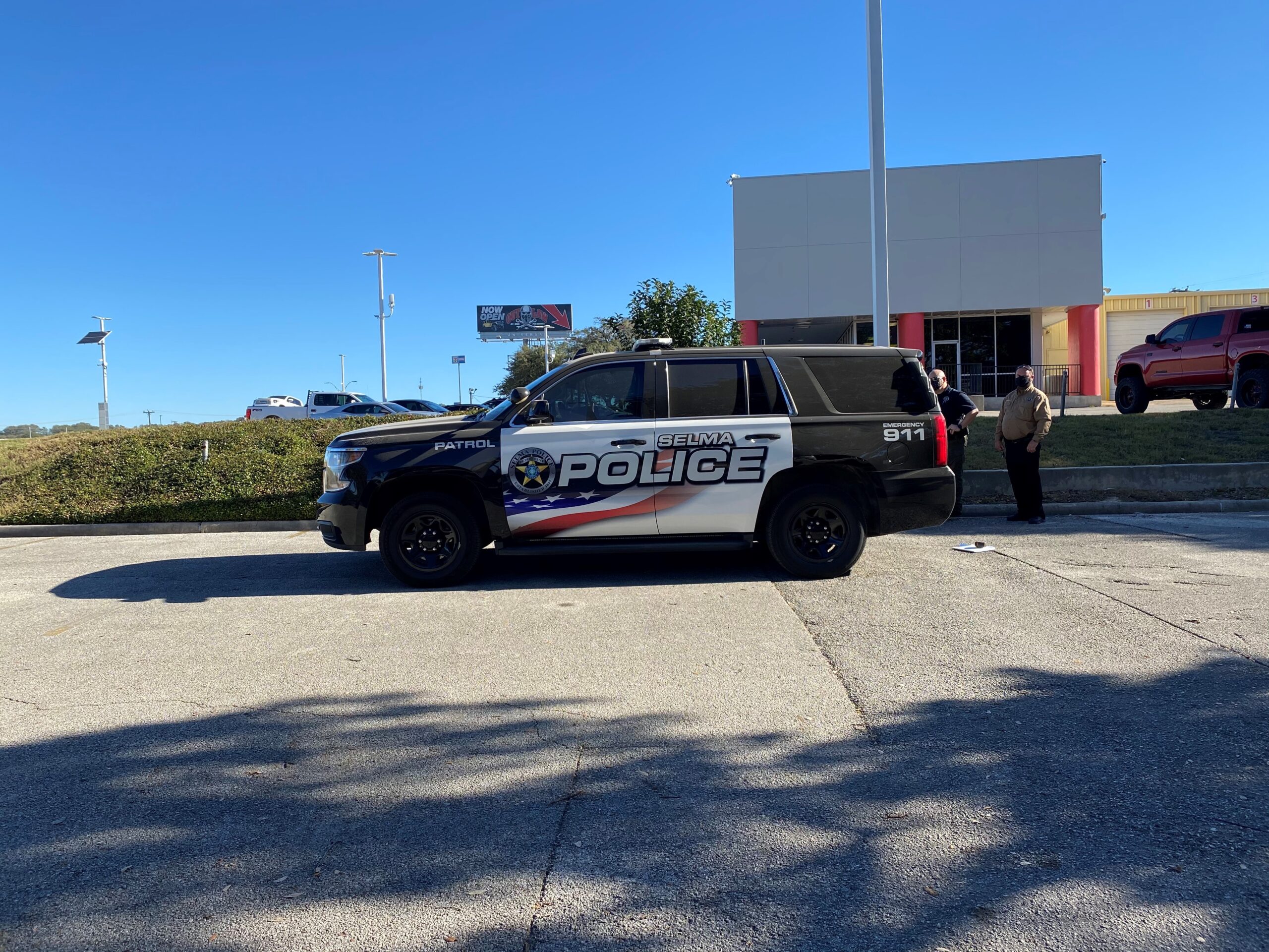 Selma police vehicle parked with officers discussing nearby, showcasing community safety and law enforcement presence.