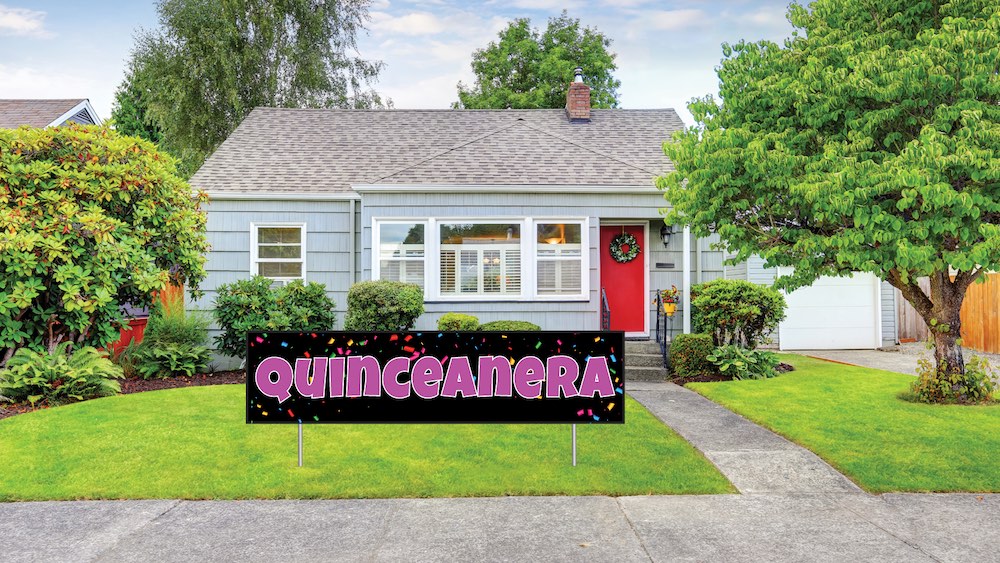 Quinceañera celebration banner in front of a suburban home, vibrant design with colorful confetti, showcasing custom signage for special occasions.
